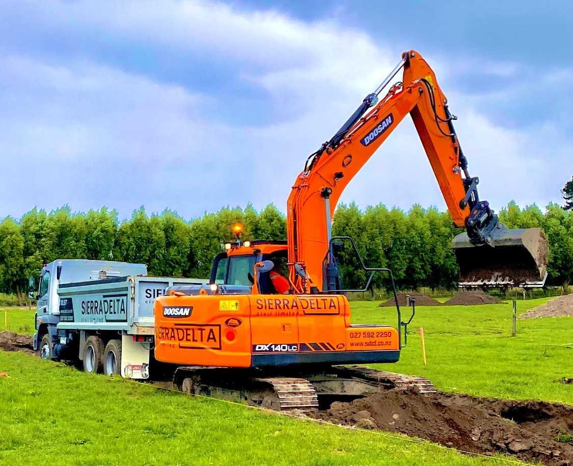 Digger scooping dirt into truck